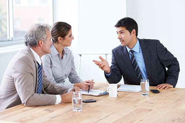 many people, european, sitting, talking, explaining, discussion, listening, paper, indoors, office, meeting, meeting room, consulting, consultant, business people, customer, sales, sales person, facilitator, customer, full shot, interviewing