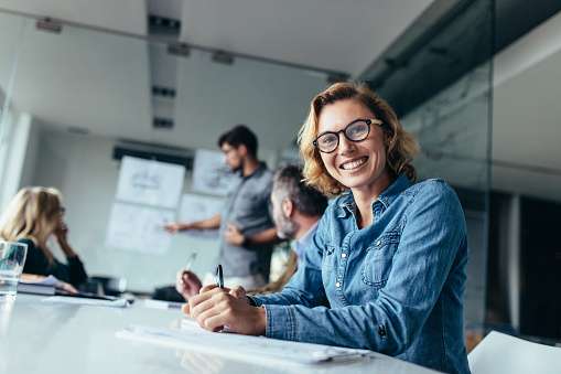 Portrait of businesswoman sitting in conference room during presentation. Caucasian woman sitting in board room.