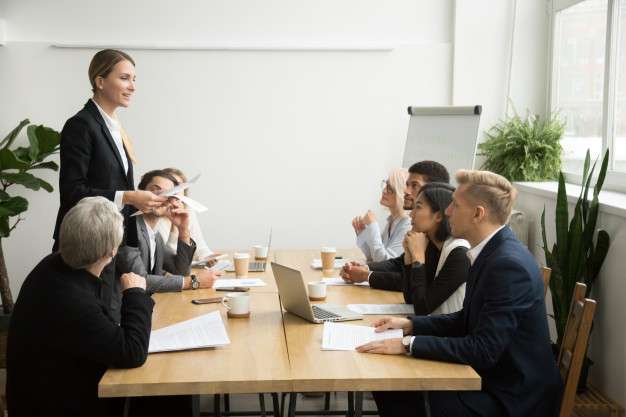 successful-female-boss-leading-team-meeting-talking-multiracial-employees_1163-4886